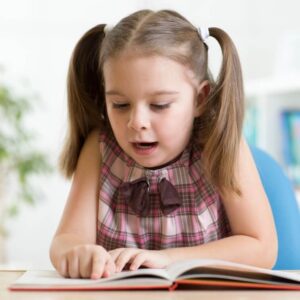 Child girl reading a book at home Kid girl reading a book at home